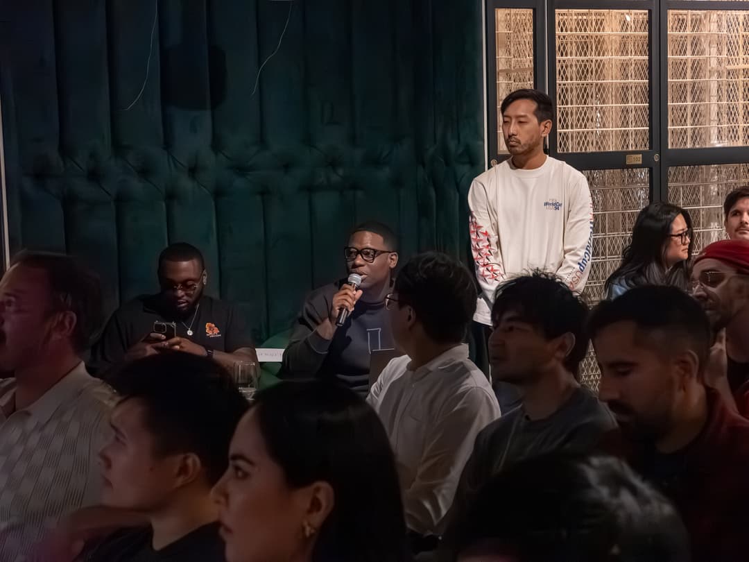 Packed room during Q&A, attendee asking a question with mic