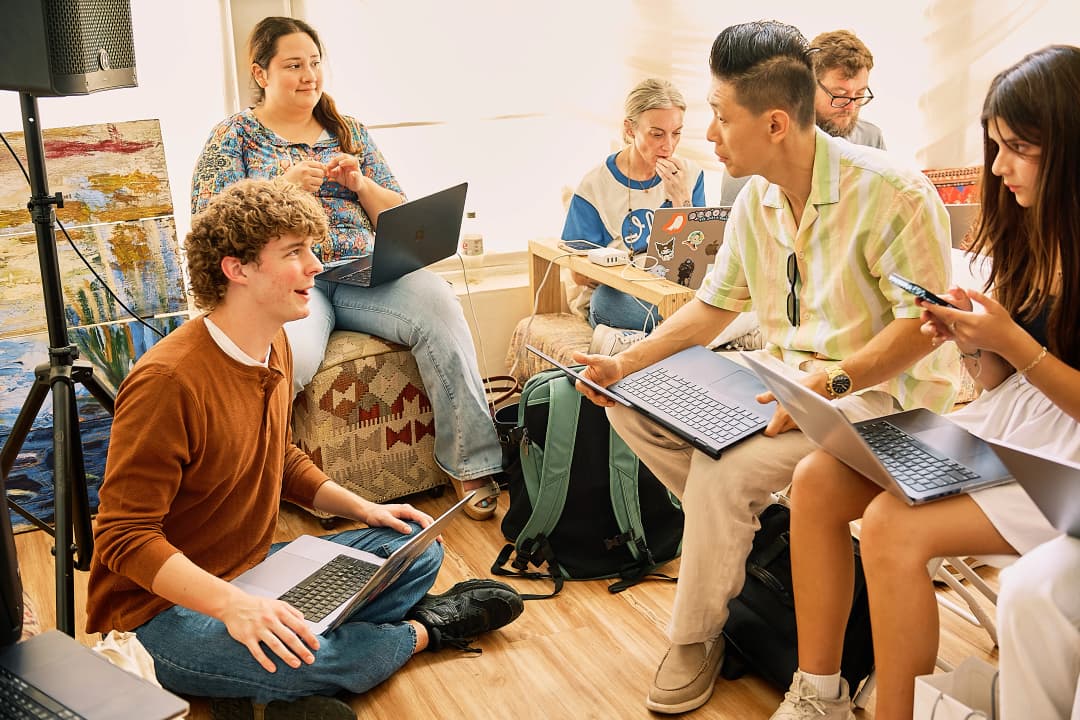 Group of attendees with laptops on the floor