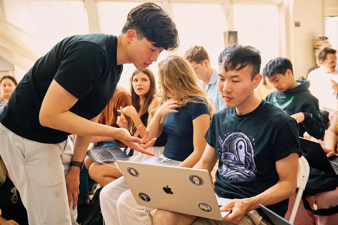 JM leaning over to help an attendee with their laptop