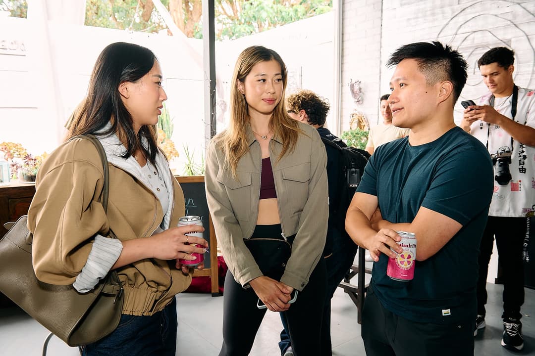 Three attendees talking near the patio doors