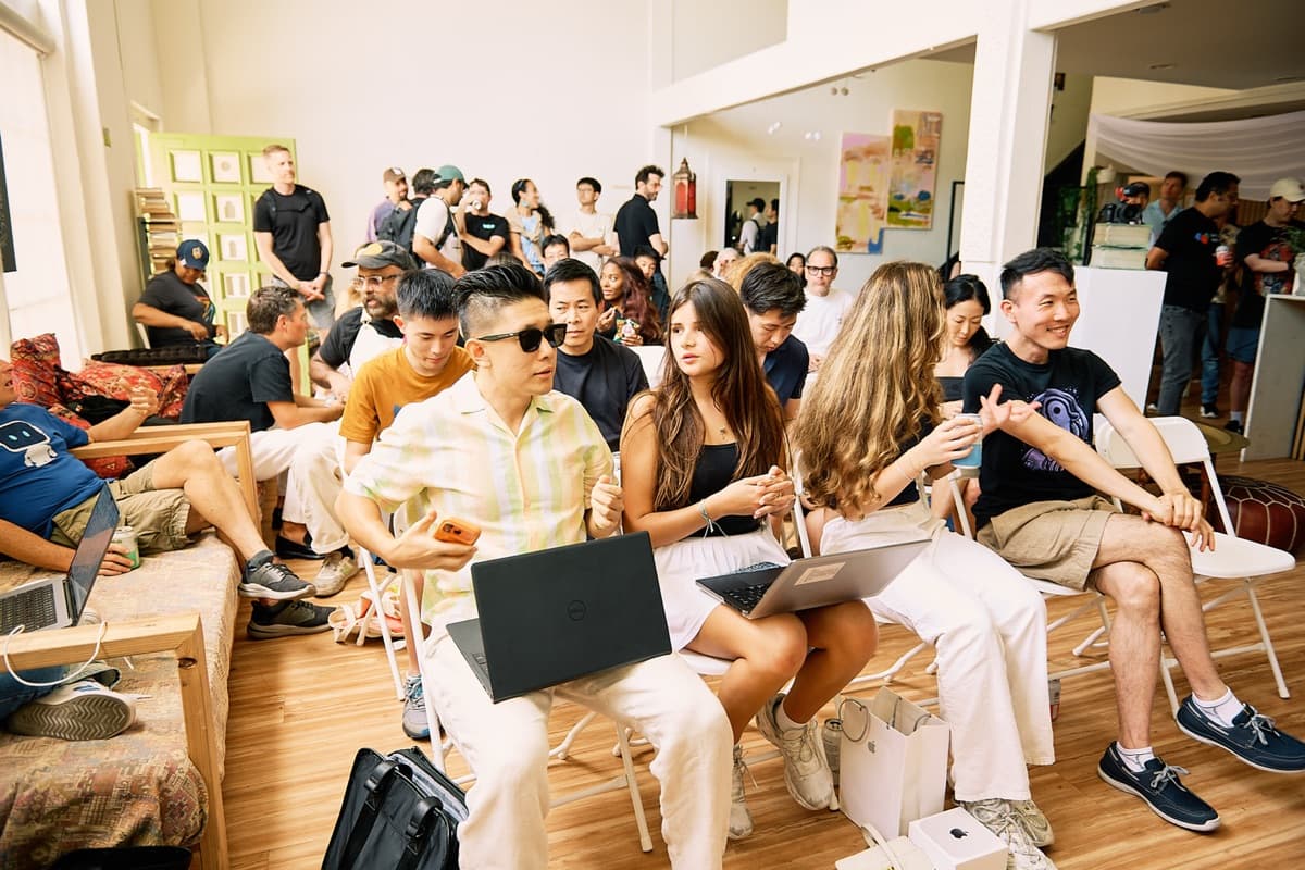 Wide shot of packed audience with laptops